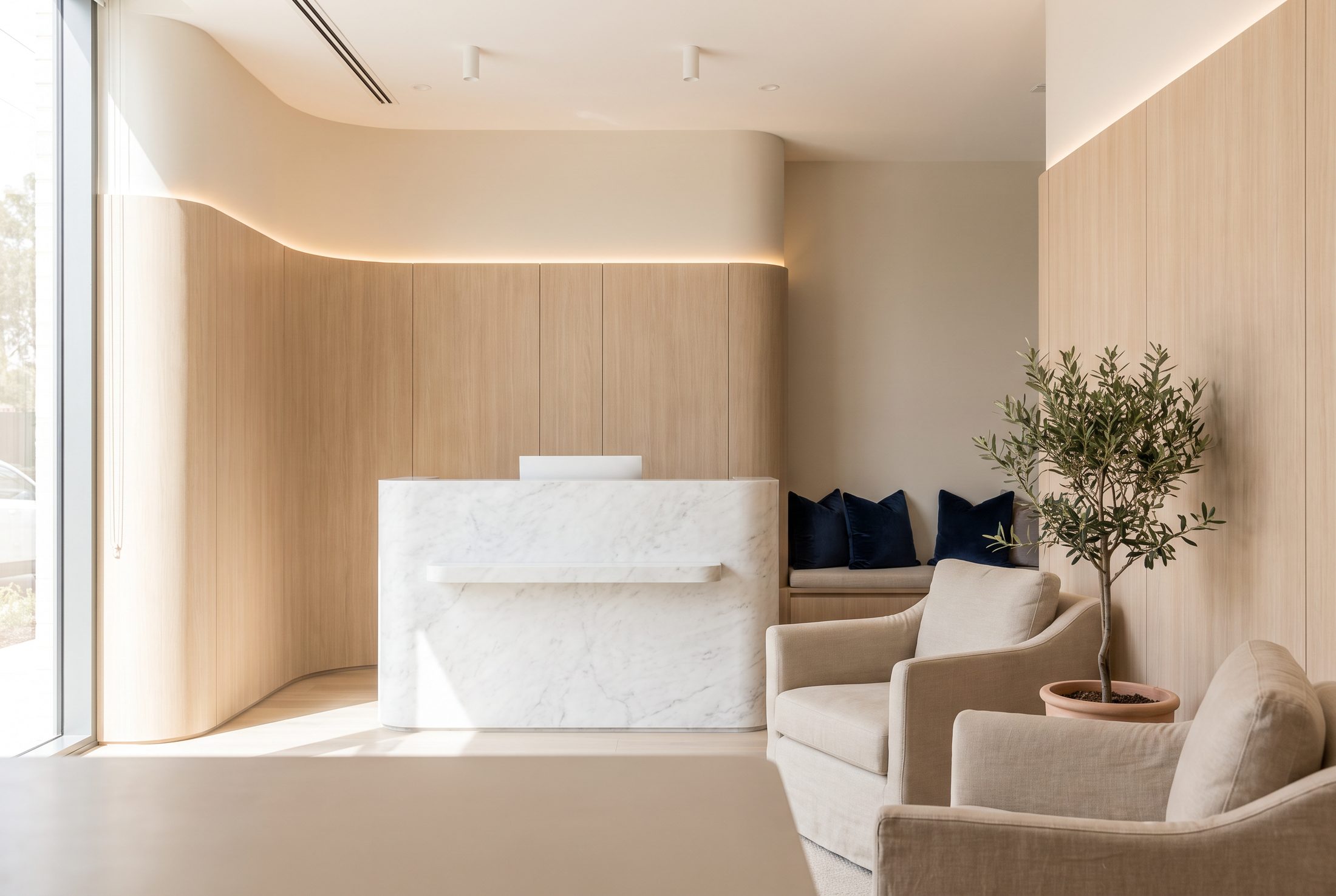 Recepção de uma clínica de estética, com balcão de mármore e poltronas